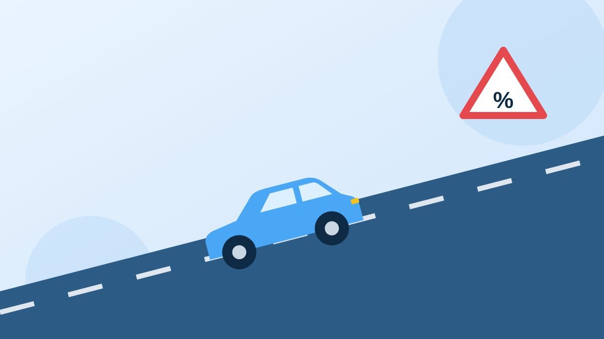 Lesauto die een helling op rijdt, met een waarschuwingsbord voor een steile helling